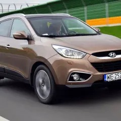 Brązowy Hyundai ix35 w ruchu drogowym, z widocznymi światłami LED i tablicą rejestracyjną WE 252 JH.