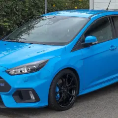 Niebieski Ford Focus MK3 RS z czarnymi felgami i spojlerem. Wiele pozytywnych ford focus mk3 opinie o tym modelu.