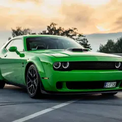 Zielony Dodge Challenger na parkingu. Sprawdź aktualną dodge challenger cena i poczuj moc tego muscle cara.