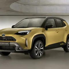 Złoty Toyota Yaris Cross 2025 Hybrid prezentuje się nowocześnie w studiu.