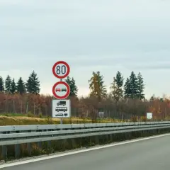 Niemieckie znaki drogowe: ograniczenie prędkości do 80 km/h, zakaz wyprzedzania dla ciężarówek i samochodów osobowych.