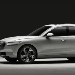 Biały Genesis GV70 na ładowarce. Elegancki SUV z charakterystycznym grillem i światłami LED.