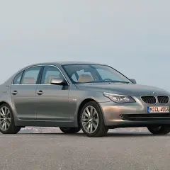 Szary sedan BMW 535d na tle górskiego krajobrazu.