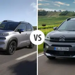 Dwa modele Citroen Aircross, jeden srebrny, drugi ciemnoszary, jadące po drodze.