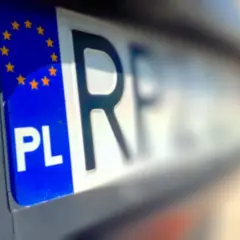 Fragment polskiej tablicy rejestracyjnej z symbolem UE i literami "PL". Wygląda jak tymczasowy dowód rejestracyjny.