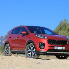 Czerwony Kia Sportage 2008 na tle gór i zieleni, gotowy na przygodę.