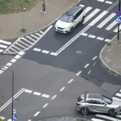Skrzyżowanie równorzędne znak. Dwa samochody zbliżają się do przejść dla pieszych.