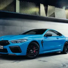 Niebieskie BMW M8 z czarnymi felgami i czerwonymi zaciskami hamulcowymi. Sprawdź aktualną bmw m8 cena.