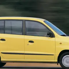 Żółty Hyundai Atos w ruchu, z rozmytym tłem sugerującym prędkość.
