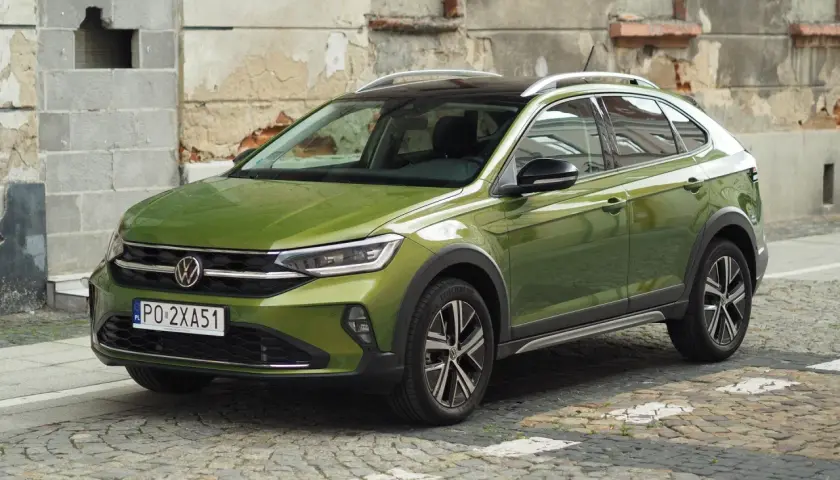 Zielony Volkswagen Taigo na brukowanej ulicy. Sprawdź atrakcyjną vw taigo cena i wybierz swój wymarzony samochód.
