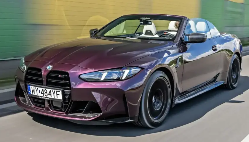 M4 CS kabriolet w kolorze śliwkowym sunie po drodze.