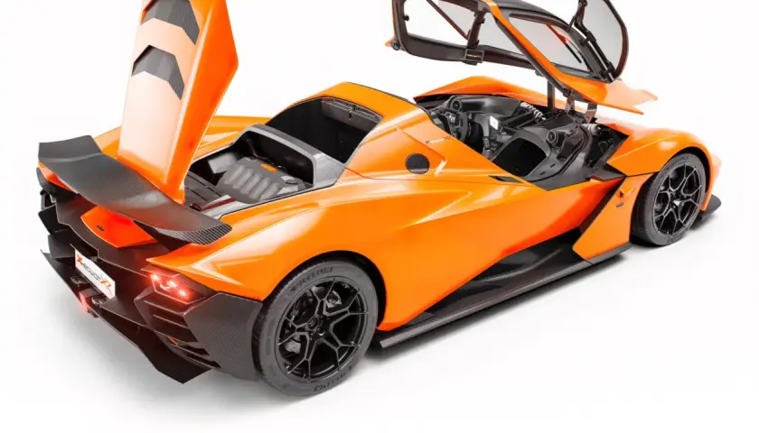 Pomarańczowy KTM X-Bow GT XR z otwartymi drzwiami i maską, ukazujący sportowy design i detale z włókna węglowego.