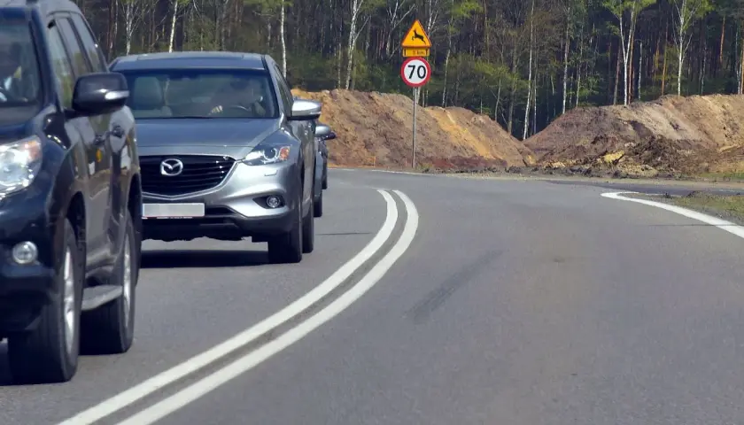 Niebezpieczne wyprzedzanie na podwójnej ciągłej, tuż obok znaku ostrzegającego przed dzikimi zwierzętami i ograniczenia prędkości do 70 km/h.