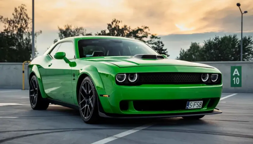 Zielony Dodge Challenger na parkingu. Sprawdź aktualną dodge challenger cena i poczuj moc tego muscle cara.