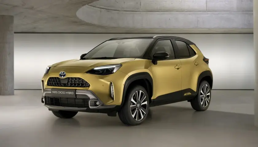 Złoty Toyota Yaris Cross 2025 Hybrid prezentuje się nowocześnie w studiu.