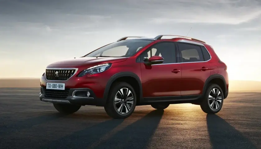 Czerwony Peugeot 2008 na tle zachodzącego słońca. Sprawdź jego wymiary i możliwości.