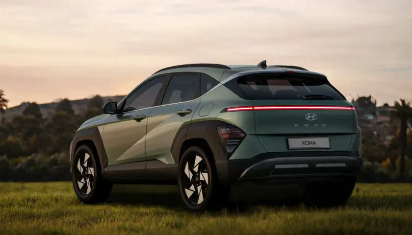Nowy Hyundai Kona w zielonym kolorze, z charakterystycznym pasem świateł z tyłu. Sprawdź atrakcyjną hyundai kona cena.