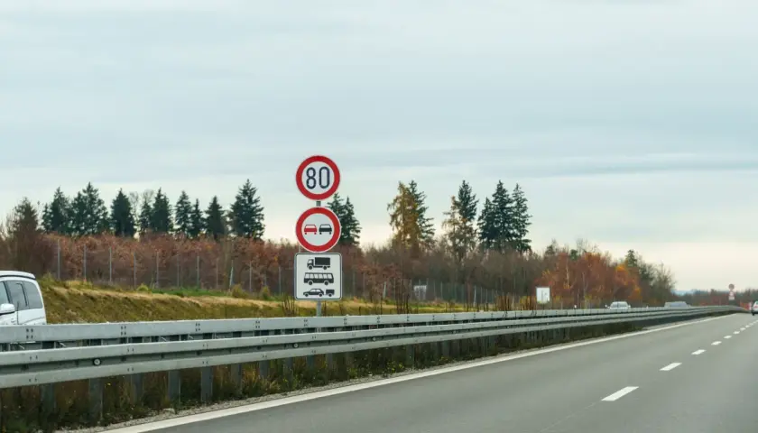 Niemieckie znaki drogowe: ograniczenie prędkości do 80 km/h, zakaz wyprzedzania dla ciężarówek i samochodów osobowych.