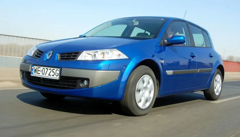 Błękitny Renault Megane 2 z polskimi tablicami WE 0725G jedzie po drodze.
