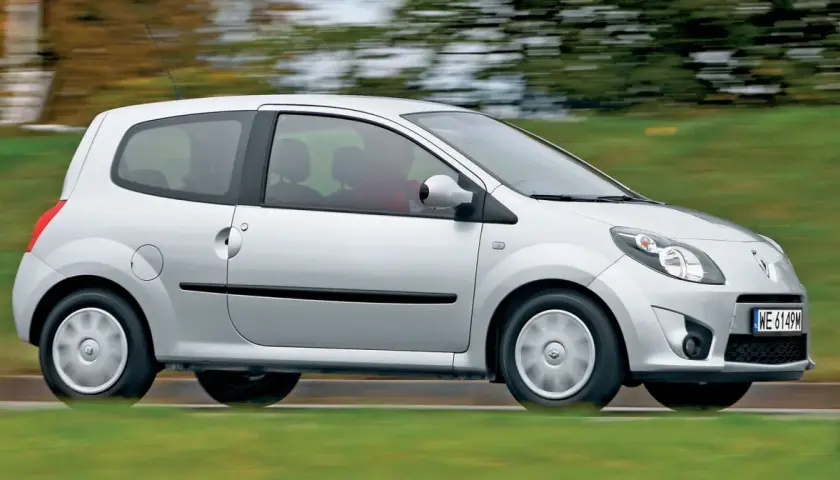 Srebrne Renault Twingo 2 w ruchu, z rozmytym tłem zieleni i drzew.