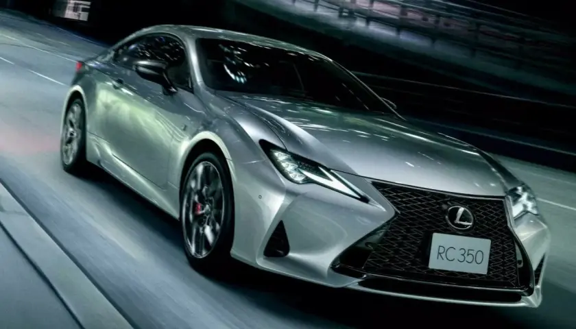 Srebrny Lexus RC 350 pędzi nocą przez tunel, jego światła przecinają mrok.