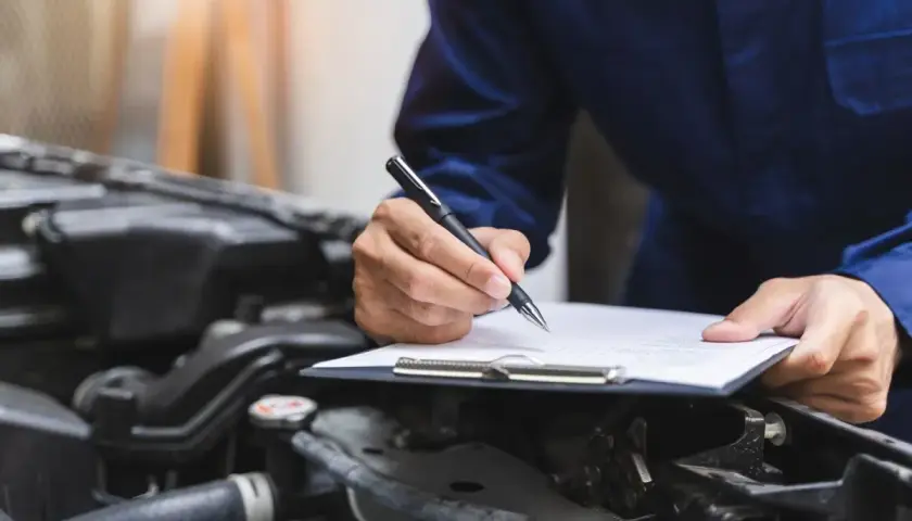 Mechanik spisuje protokół przeglądu, by uniknąć kary za spóźniony przegląd.