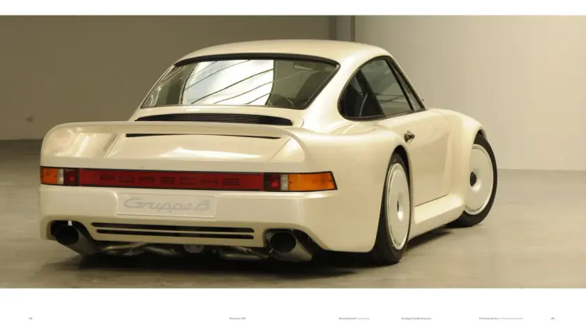 Biały Porsche 959 z napisem "Gruppe B" na tyle, prezentujący swoje charakterystyczne linie i podwójne końcówki wydechu.