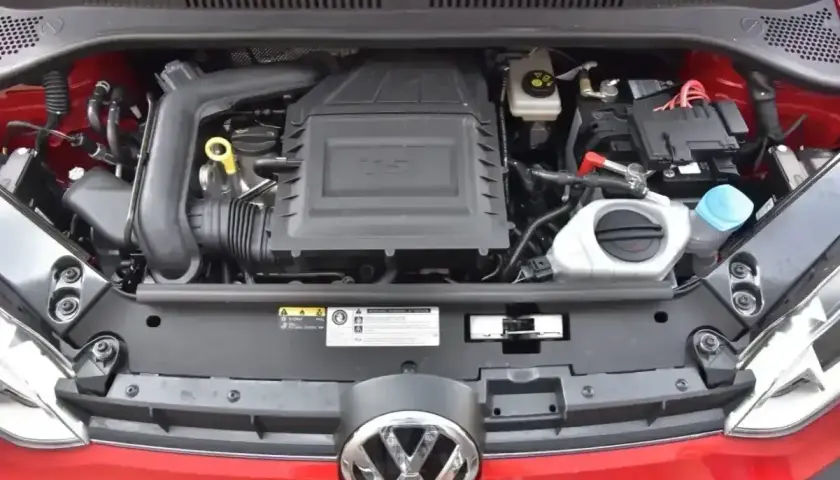 Silnik 1.0 TSI w czerwonym Volkswagenie. Widoczny jest układ dolotowy, akumulator i płyny eksploatacyjne.