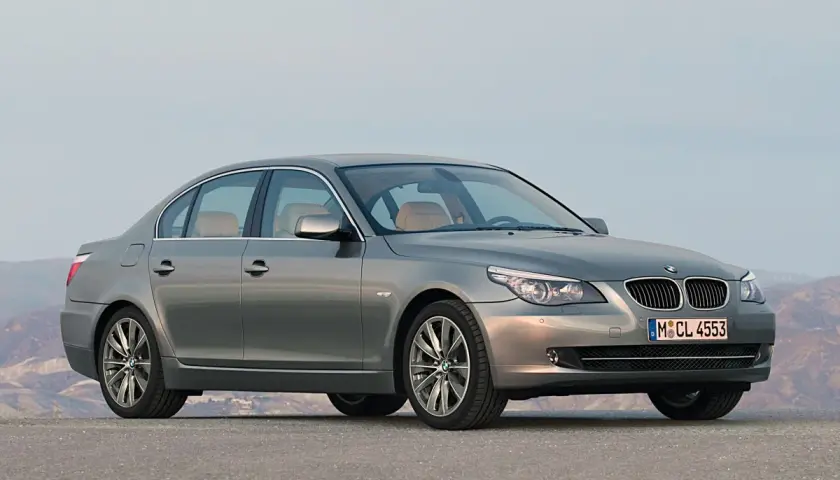Szary sedan BMW 535d na tle górskiego krajobrazu.