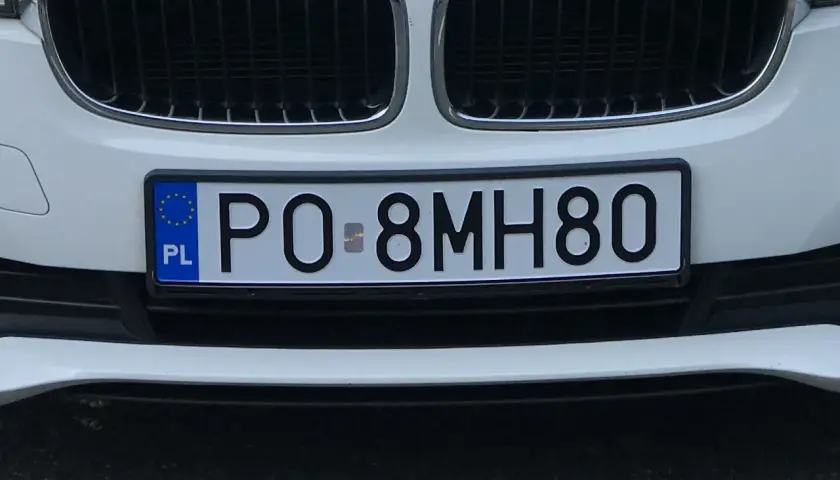 Biały samochód z polską tablicą rejestracyjną PO 8MH80.