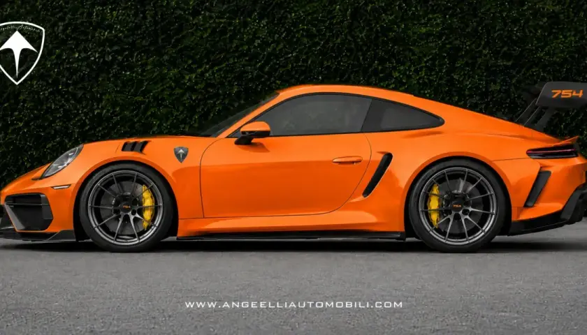 Pomarańczowy Porsche RWB z czarnym spoilerem i felgami, na tle zielonego żywopłotu.
