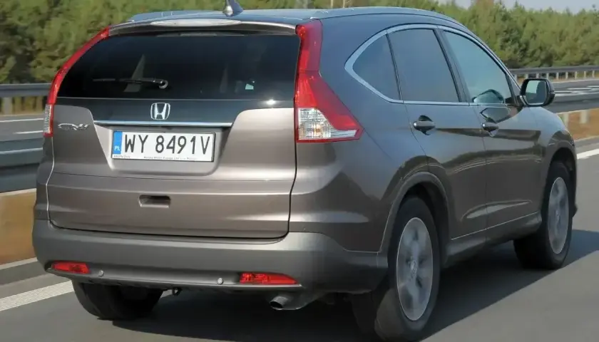 Honda CR-V 2.0 benzyna w kolorze brązowym jedzie po drodze.
