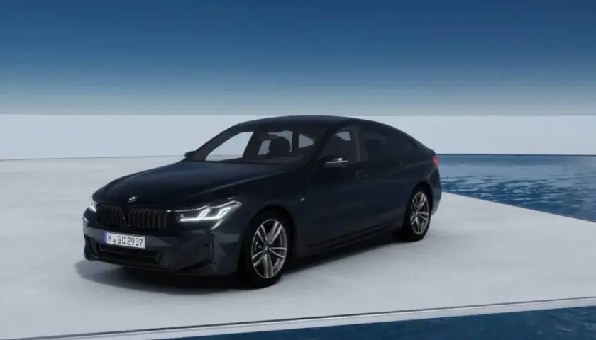 Eleganckie bmw g32 w ciemnym kolorze prezentuje się na platformie nad wodą, z błękitnym niebem w tle.
