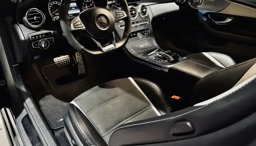 Wnętrze sportowego Mercedesa z kierownicą AMG, karbonowymi wstawkami i siedzeniami. Czekam na jazdę tym v8!