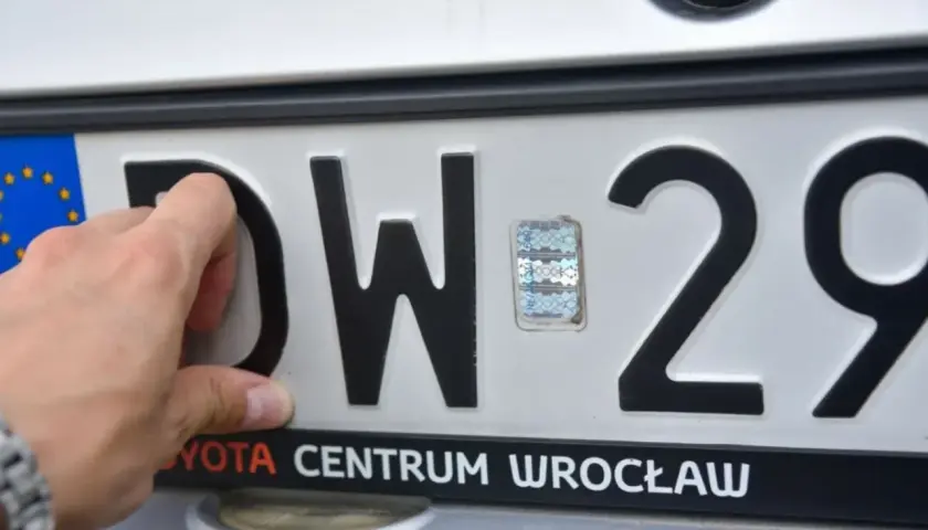 Ręka dotyka litery D na tablicy rejestracyjnej DW 29. Tst rejestracja w Toyota Centrum Wrocław.