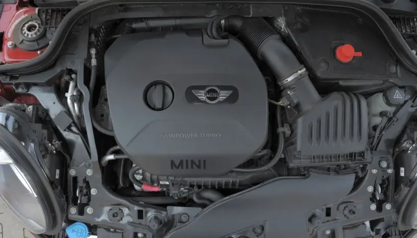 Silnik TwinPower Turbo w Mini F56. Widoczny czarny plastikowy wlot powietrza i czerwony korek.