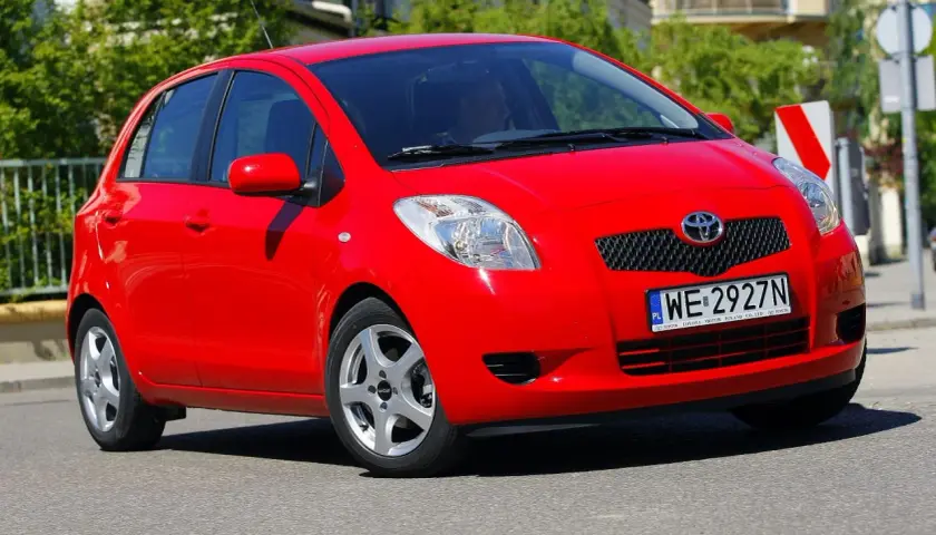 Czerwony Toyota Yaris 2008 na drodze, z widocznym numerem rejestracyjnym WE 2927N.