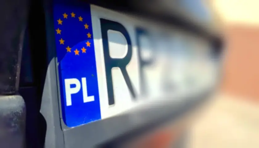 Fragment polskiej tablicy rejestracyjnej z symbolem UE i literami "PL". Wygląda jak tymczasowy dowód rejestracyjny.