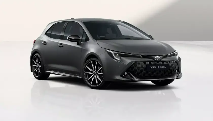 Szary hatchback Toyota Corolla 1.8 Hybrid z czarnymi felgami stoi na białym tle.