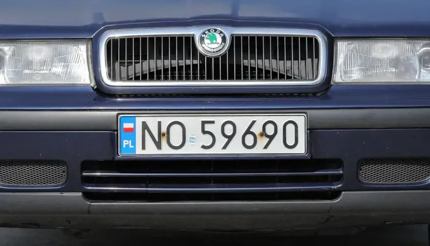 Niebieska Skoda z tablicą rejestracyjną NO 59690. Cały przód auta, grill i światła.