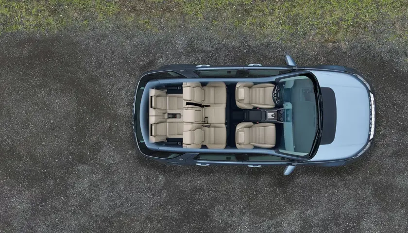 Widok z góry na wnętrze Land Rover Discovery z jasnymi, skórzanymi siedzeniami, gotowe na rodzinną podróż.
