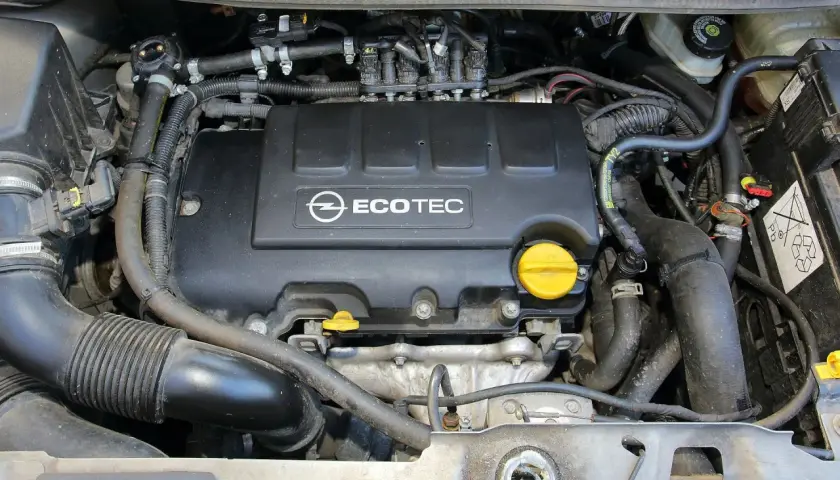 Silnik Ecotec w Oplu Meriva 1.4 benzyna. Widoczne przewody, wtryskiwacze i osłona silnika.