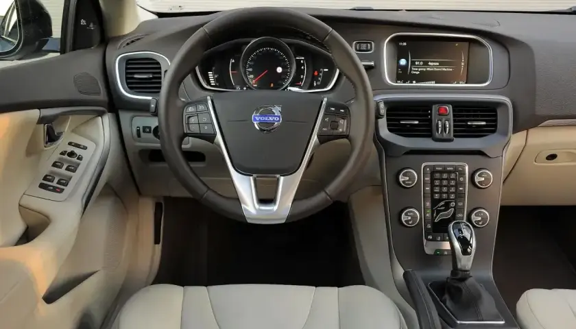 Wnętrze Volvo V40, które wielu kierowców chwali w swoich **volvo v40 opinie**. Widoczna kierownica, deska rozdzielcza z ekranem i konsola środkowa.
