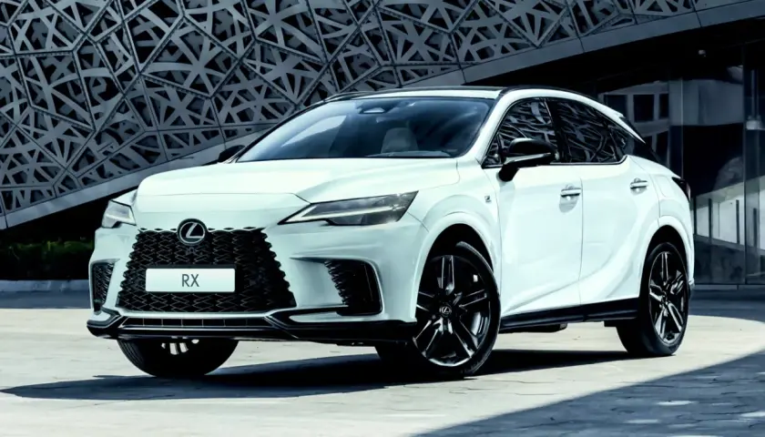 Biały Lexus RX 500h z czarnymi felgami stoi przed nowoczesnym budynkiem o geometrycznej fasadzie.