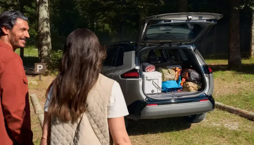 Para wyładowuje bagażnik Toyoty RAV4, gotowa na przygodę. Wymiary bagażnika pozwalają na spakowanie wszystkiego.