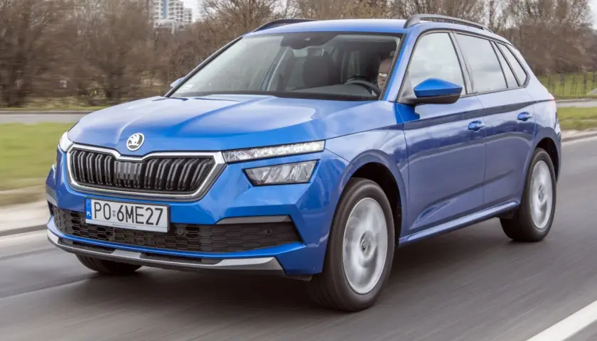 Niebieska Skoda Kamiq w ruchu drogowym. Kierowca za kierownicą. Wiele pozytywnych skoda kamiq opinie potwierdza jej wszechstronność.
