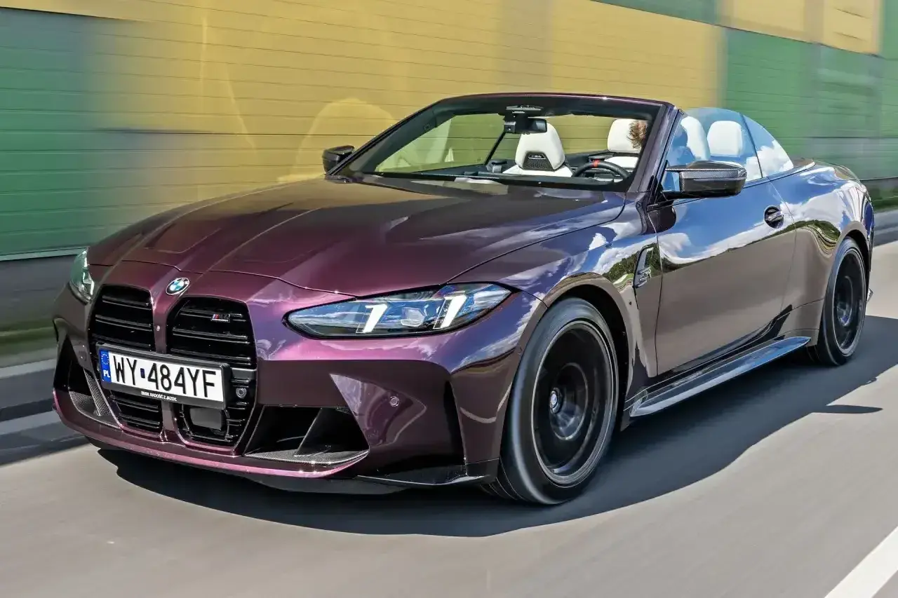 M4 CS kabriolet w kolorze śliwkowym sunie po drodze.
