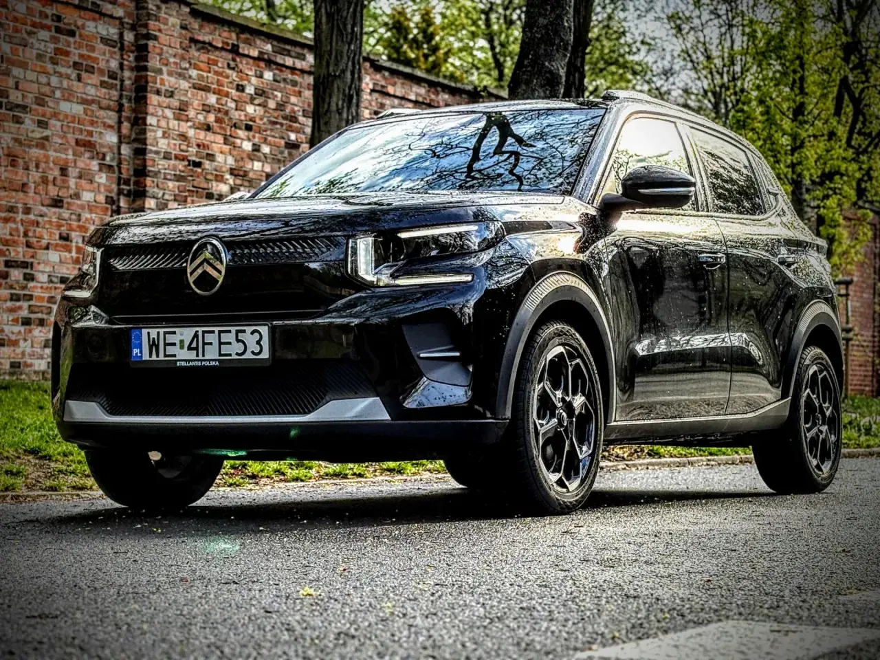 Czarny Citroen C3 na tle ceglanego muru i drzew. Wiele osób szuka **Citroen C3 opinie** przed zakupem.