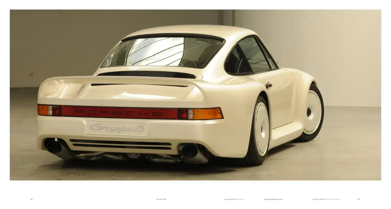 Biały Porsche 959 z napisem "Gruppe B" na tyle, prezentujący swoje charakterystyczne linie i podwójne końcówki wydechu.