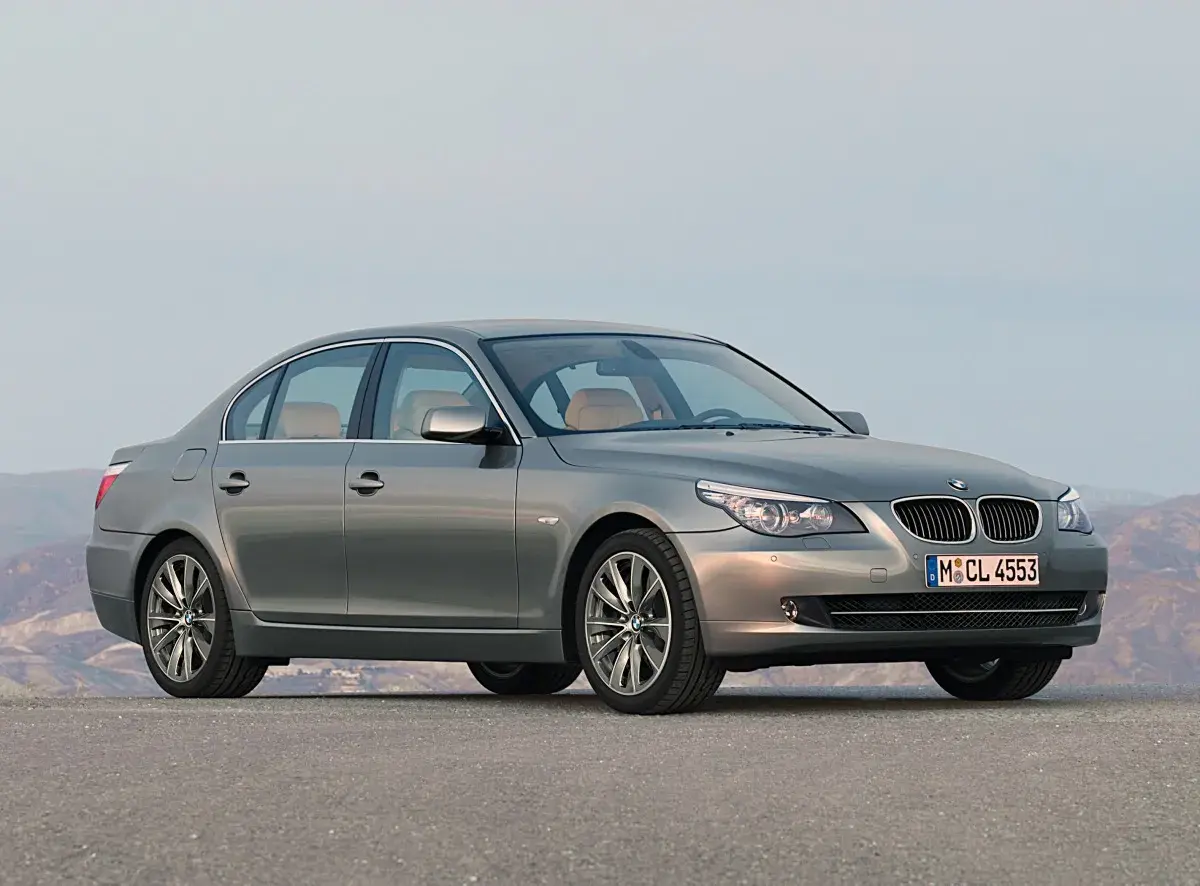 Szary sedan BMW 535d na tle górskiego krajobrazu.